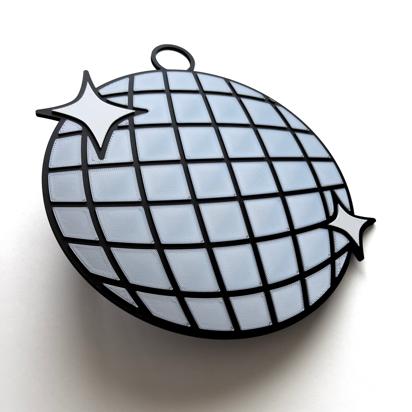 3D printed disco ball prop sign with reflective silver tiles and white sparkle accents.