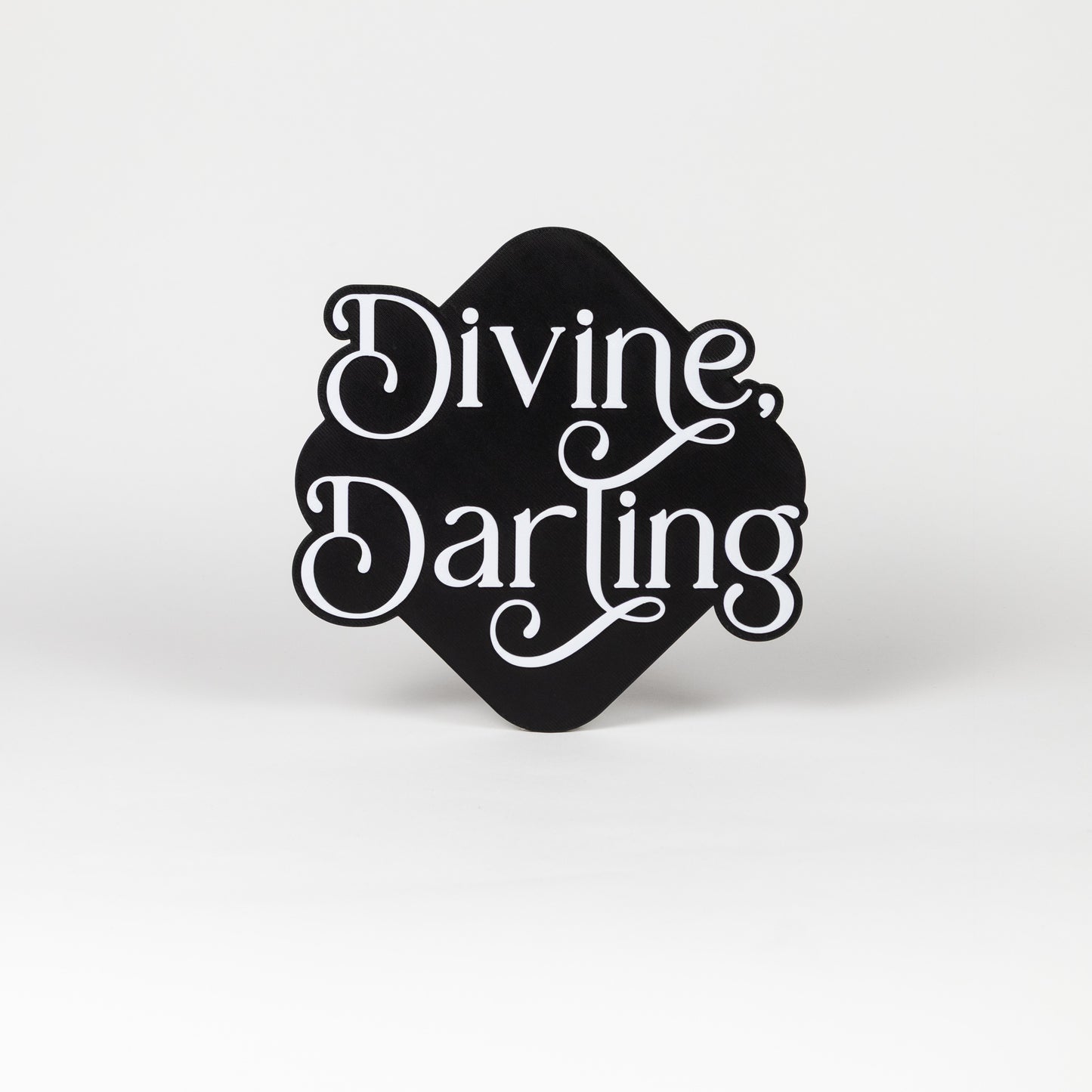 Black and white photo booth prop with 'Divine, Darling' text on a white background.
