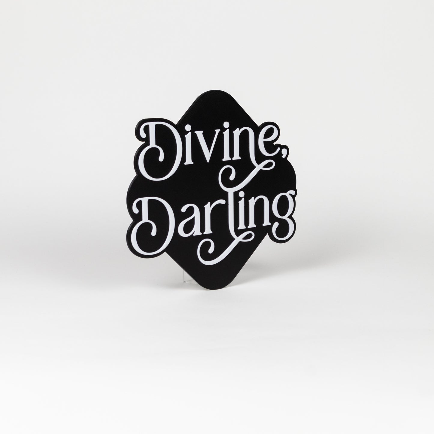 Orthogonal view of black and white sign with 'Divine Darling' text on a white background