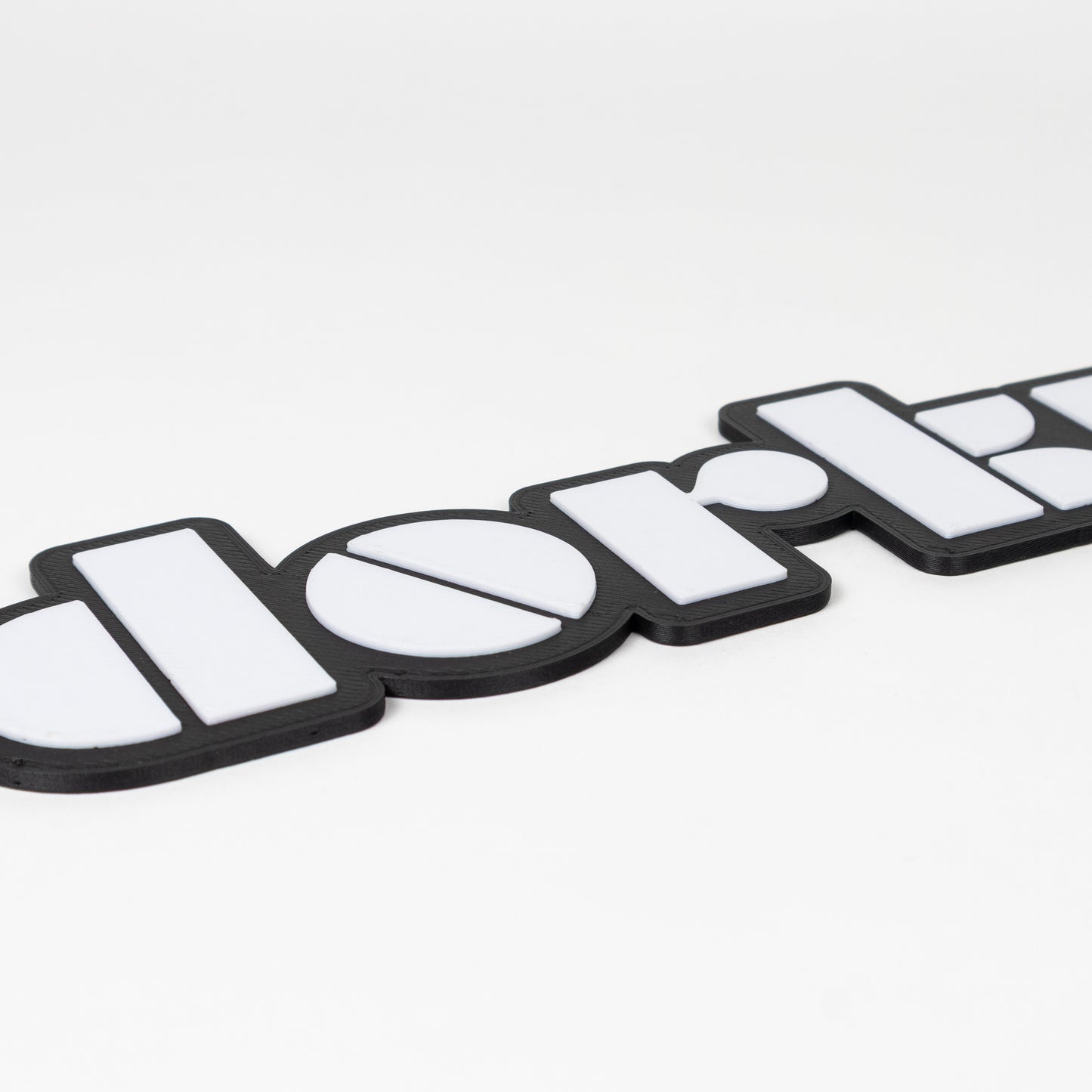 Close up shot of photo booth prop that says "dorky". Features raised white lettering on a matte black base. Shot on a white background.