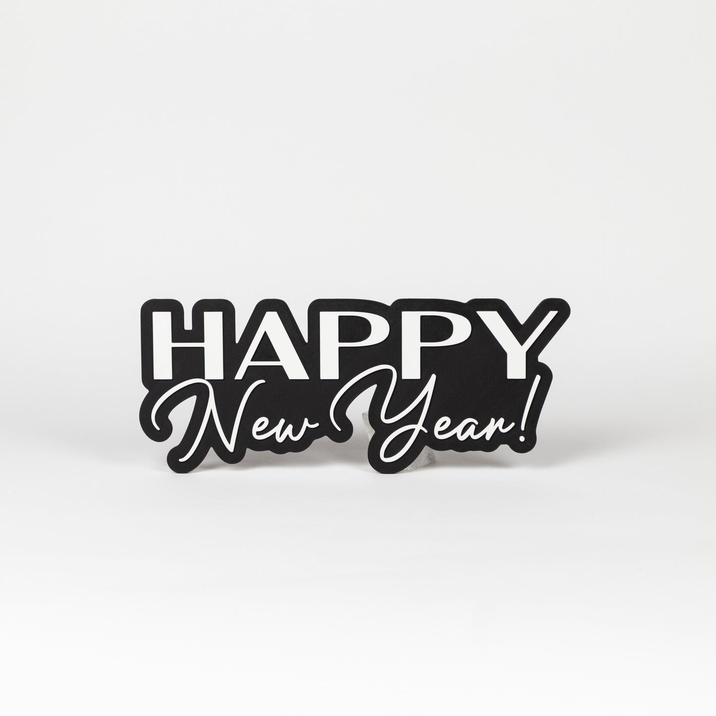Photo booth prop sign with 'Happy New Year!' text on a black base. Shot on a white background