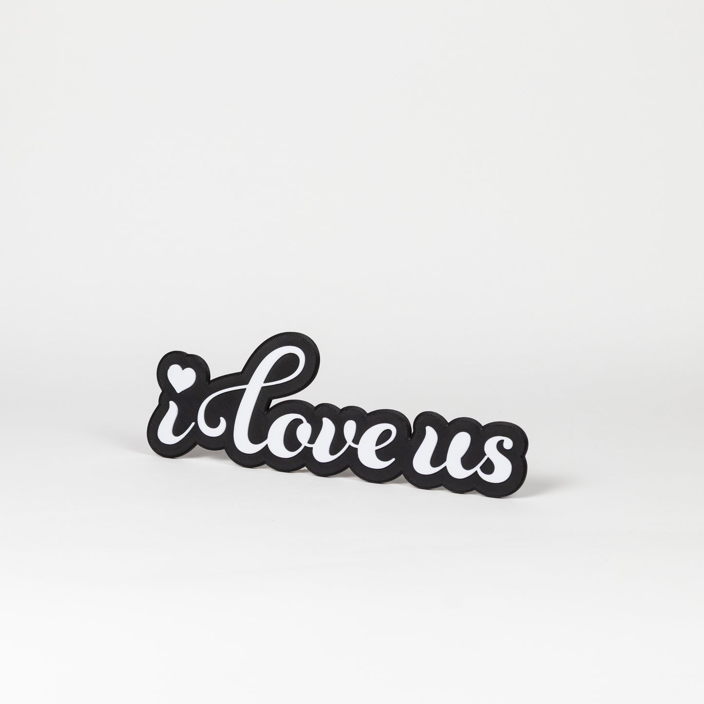 Black and white photo booth prop with 'i love us' text on a black base.