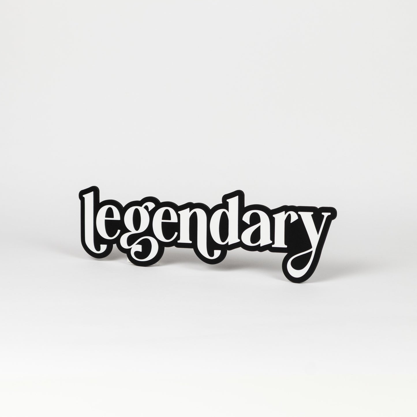 Photo booth prop sign. Black base with white 'legendary' text on a white background