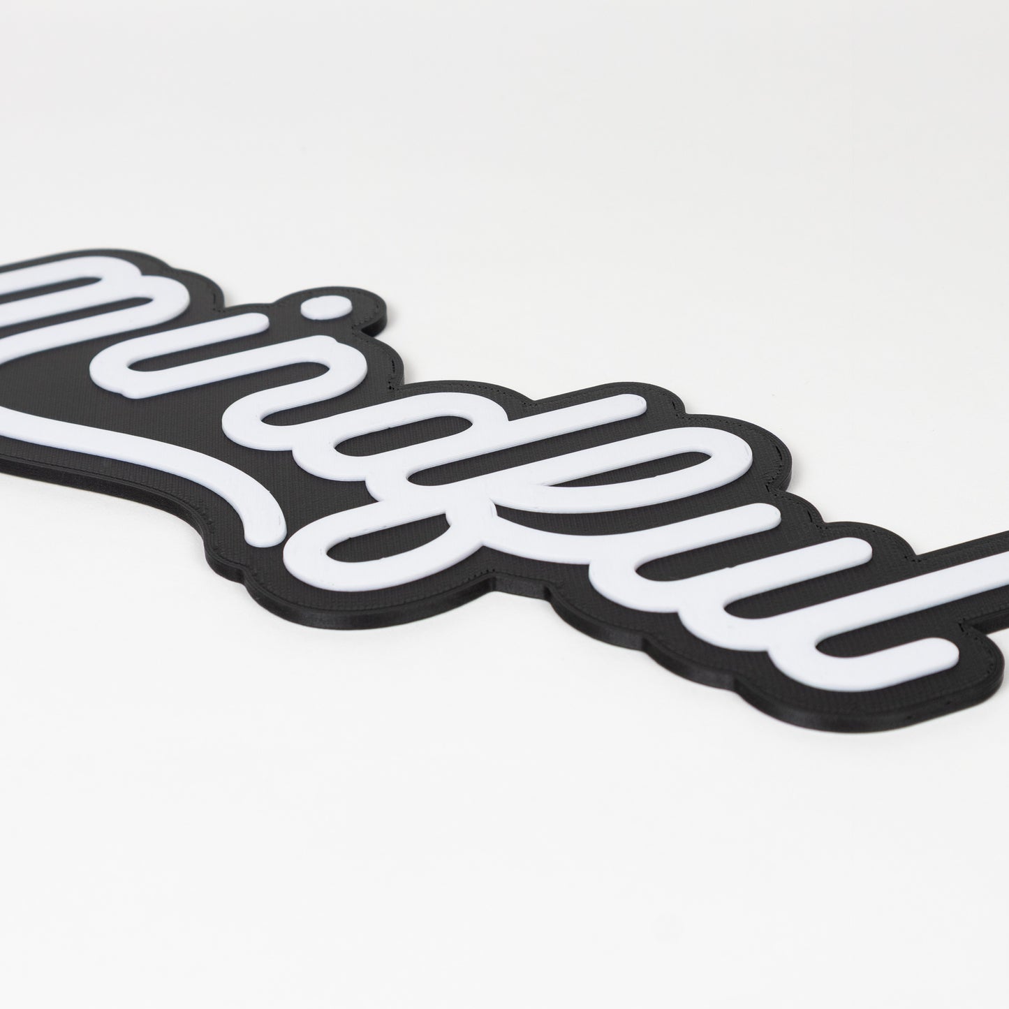 Close up shot of raised white text on a black base. Photo booth prop sign that says 'mindful' shot on a white background