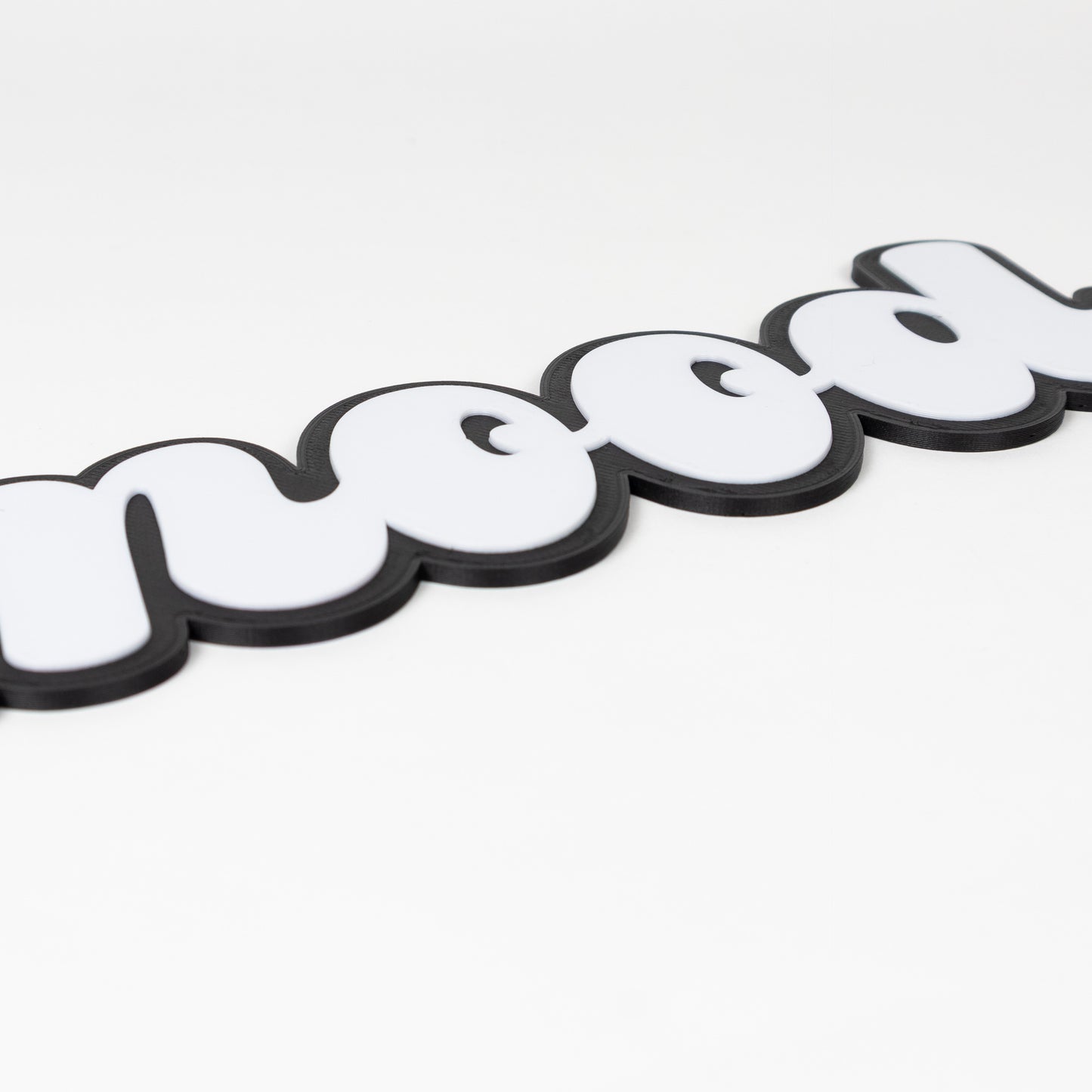 Close up of a photo booth sign that shows raised white text on a black base. Photo booth sign says, "mood"