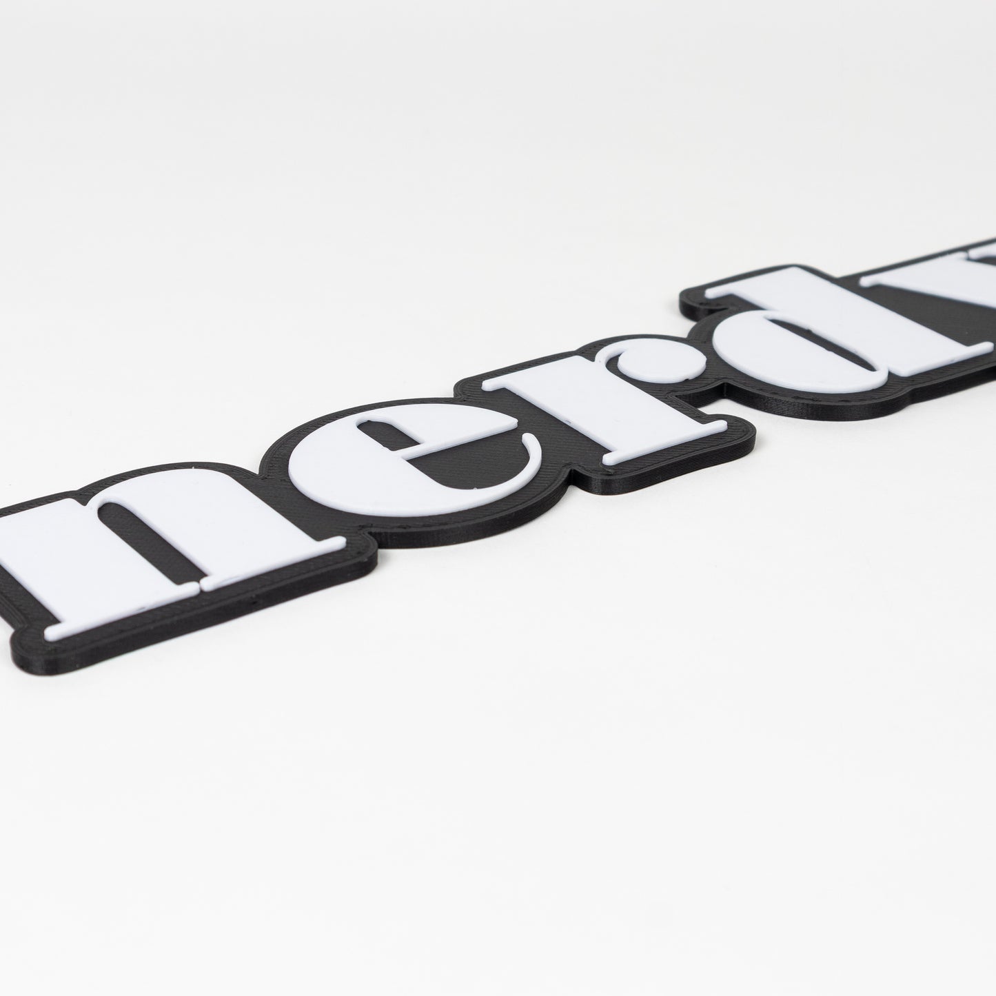 Close up of a "Nerdy" sign prop that shows raised white text on black base.