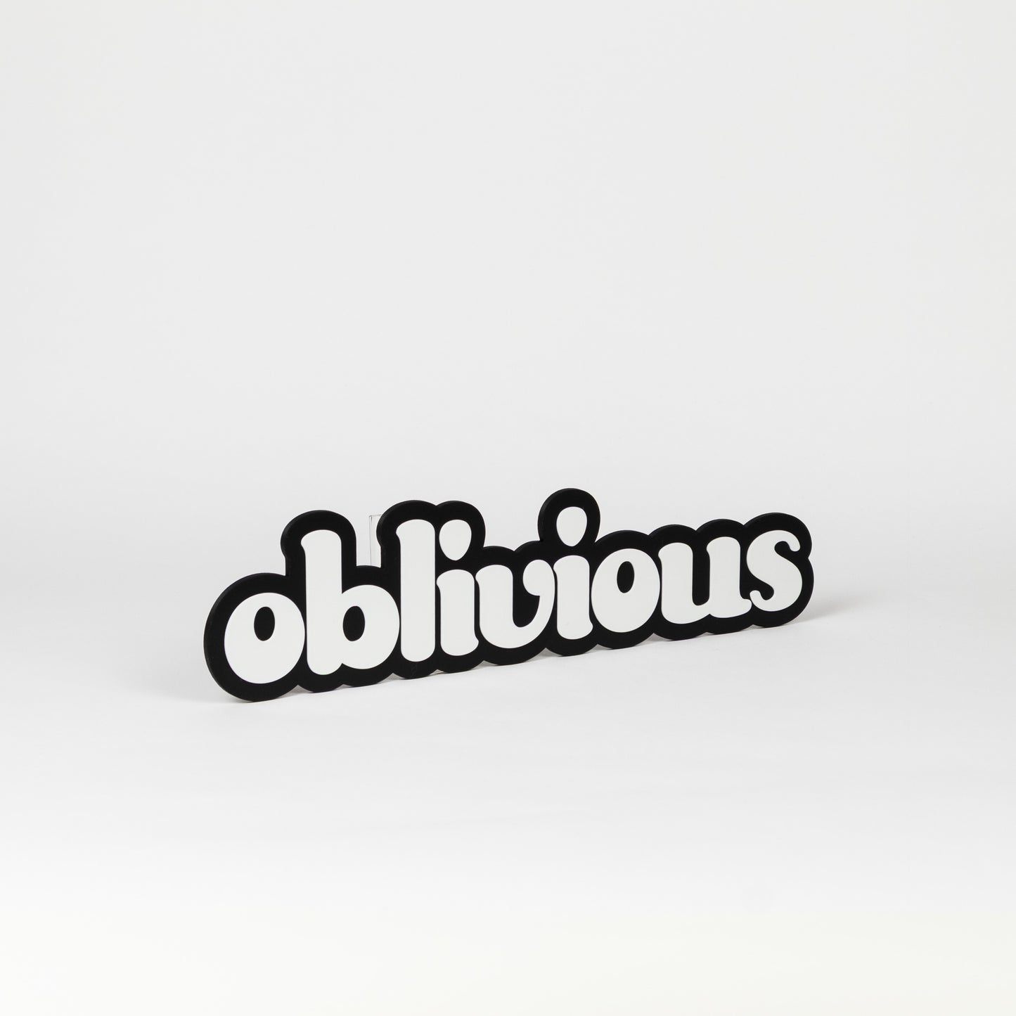Black and white photo booth prop of the word 'oblivious'.