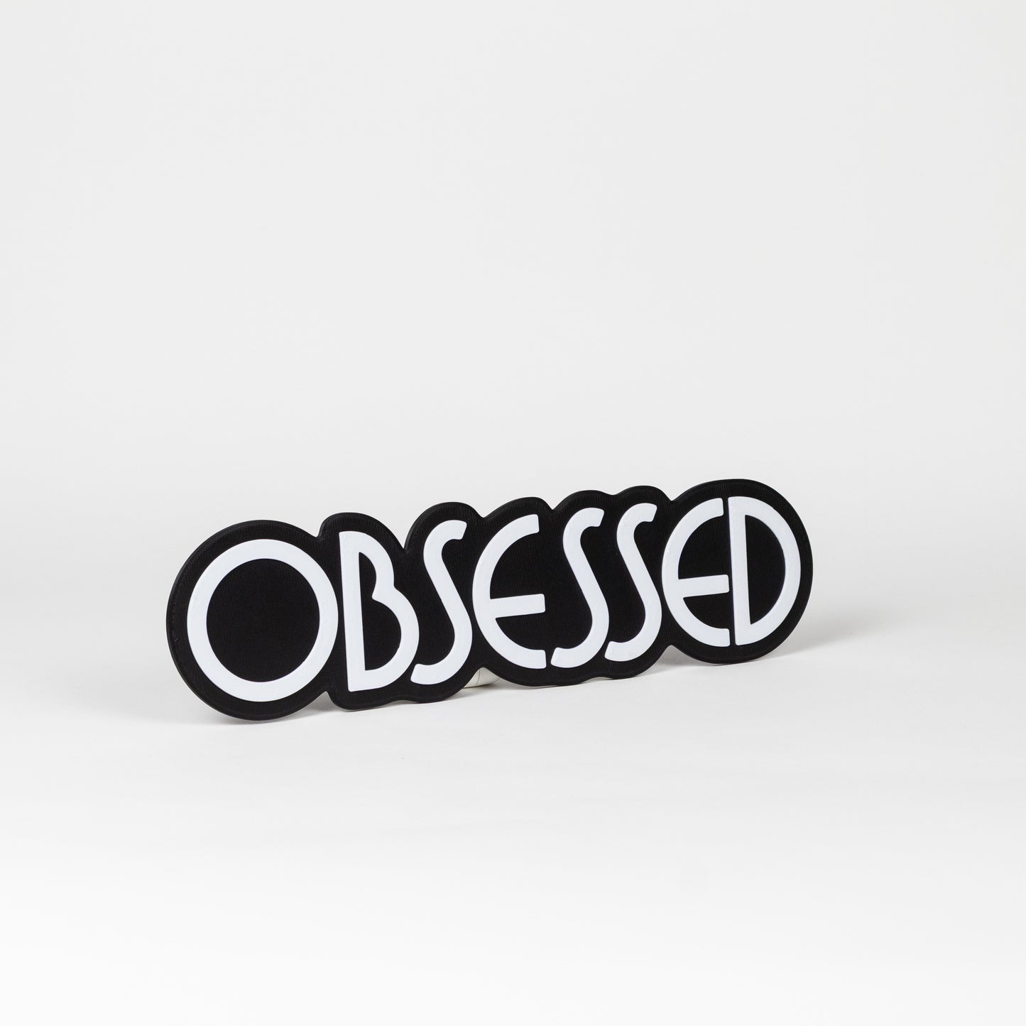 Black and white "Obsessed" sign. Photo booth prop.