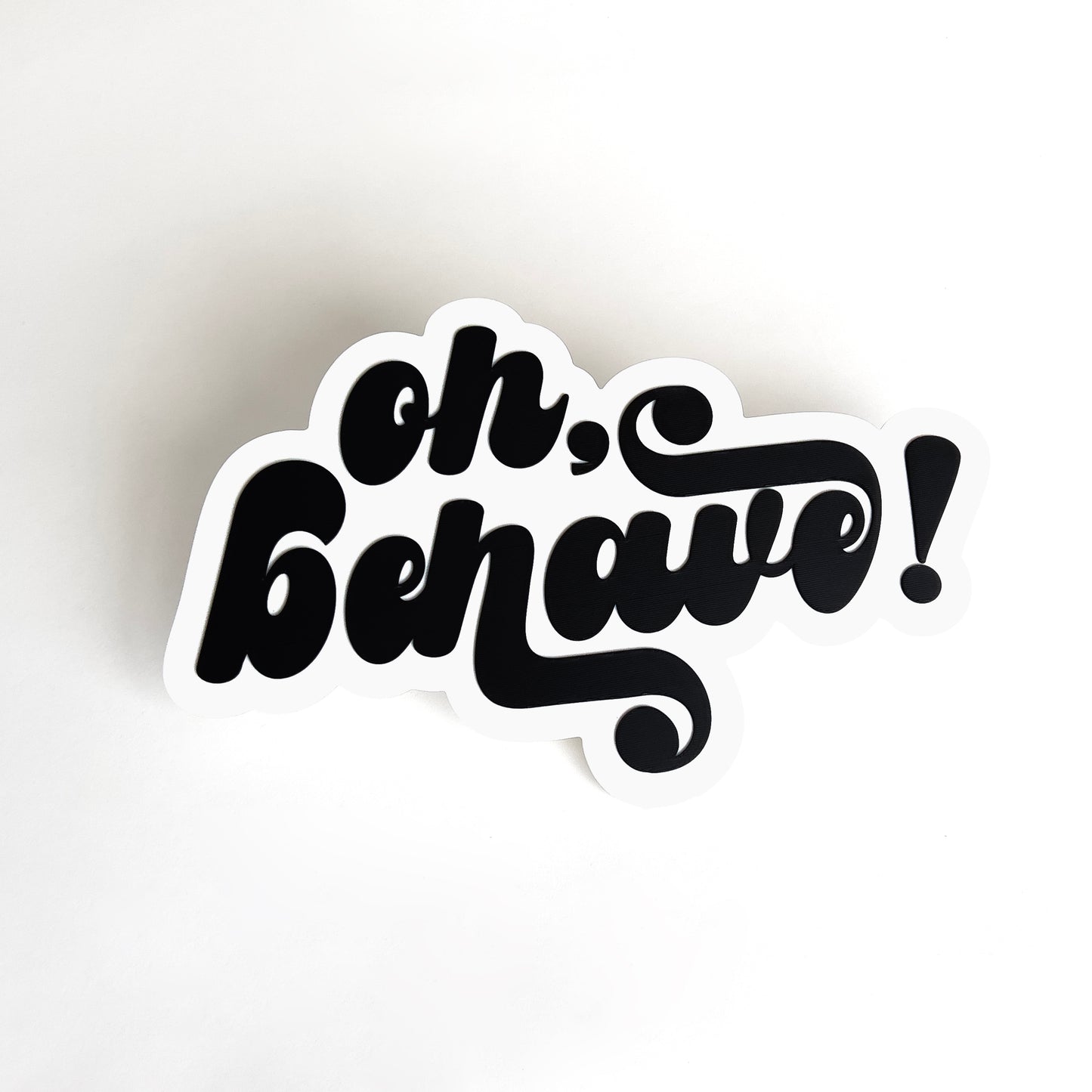 White and black photo booth prop sign that says "oh, behave!", 60s inspired.