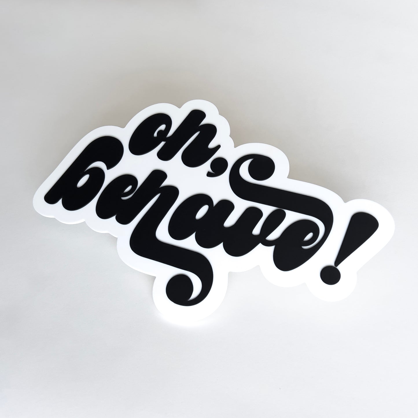 White and black photo booth prop sign that says "oh, behave!".