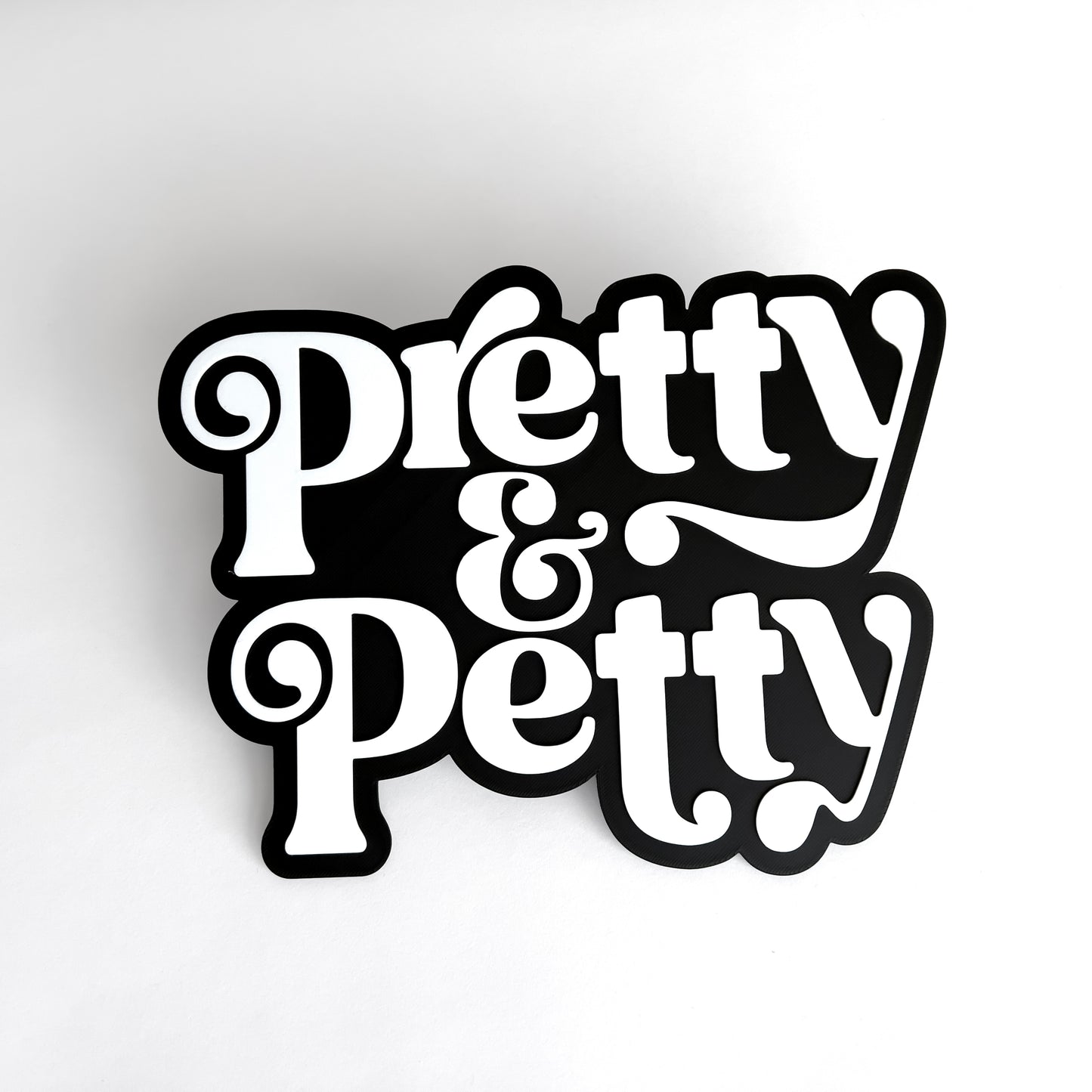 Black and white sign that says "Pretty and Petty" for photo booth events.