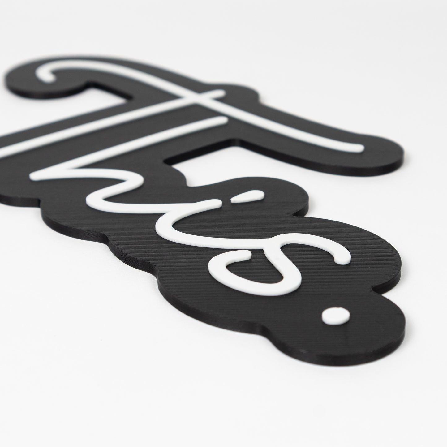 Close up photo raised white text on a black base. Black and white sign of the word "This." Photo booth prop of popular saying.