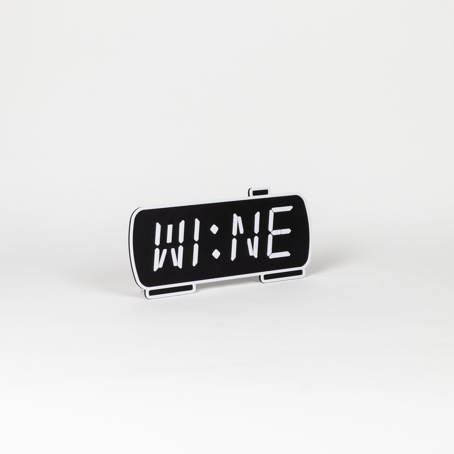 Black and white photo prop of a digital clock displaying 'WINE'.