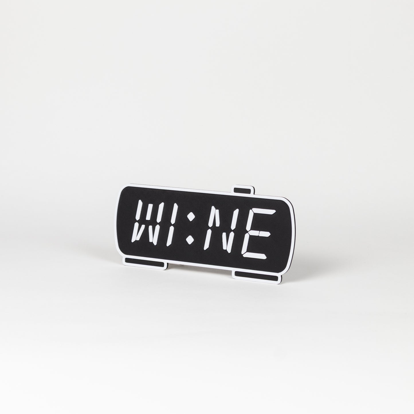 Black and white photo prop of a digital clock displaying 'WINE'.
