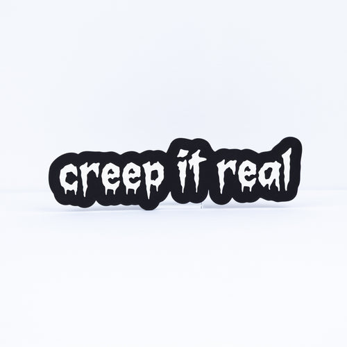 3D printed black sign with white stylized text that says, "creep it real". Shot on a white background.