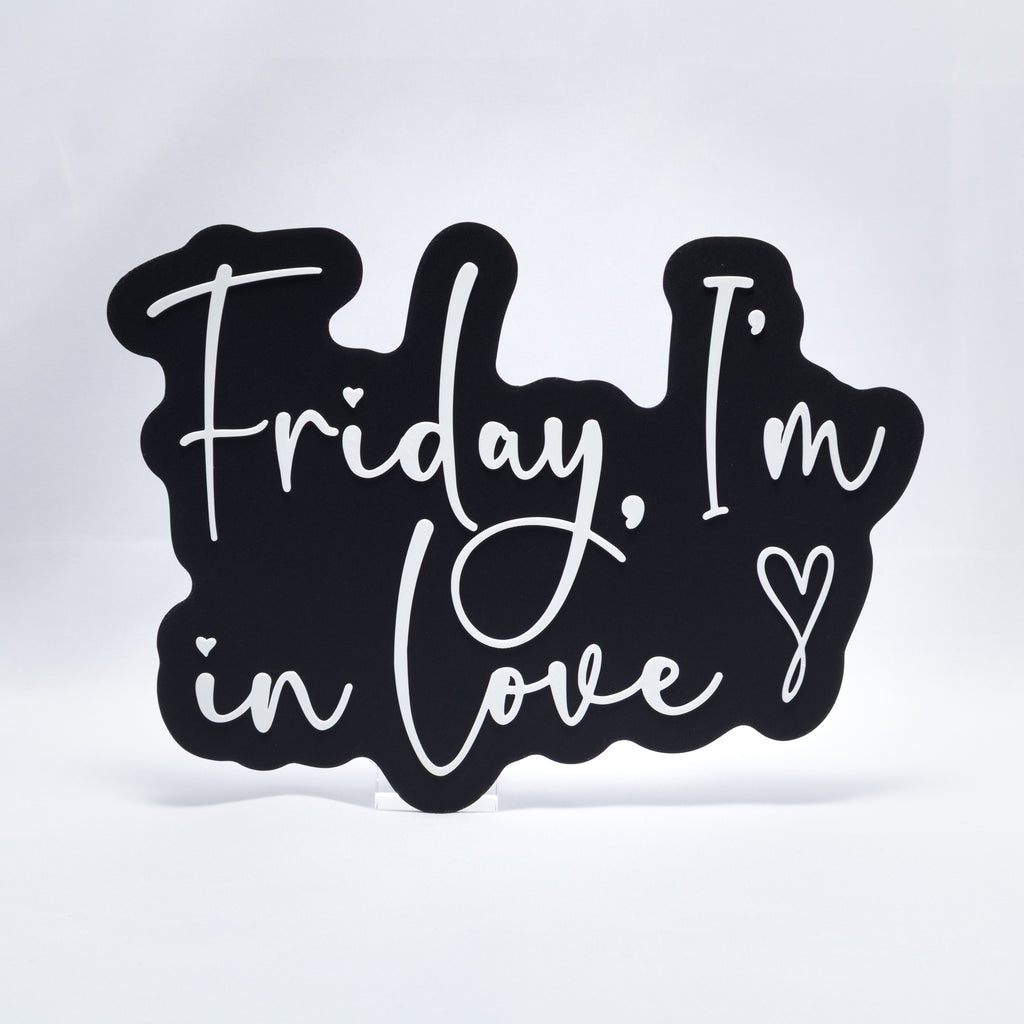 A 3D printed sign with white text on a black base that says, "Friday, I'm In Love" with a heart at the end. Inspired by The Cure song, Friday I'm In Love.