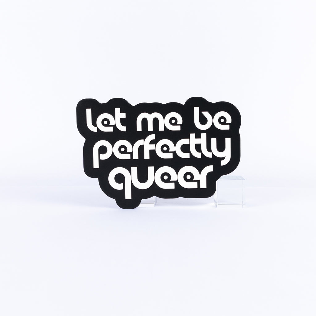 Black and white sign with white text 'Let me be perfectly queer' on a white background