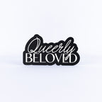 Black and white sign with 'Queerly Beloved' text on a white background