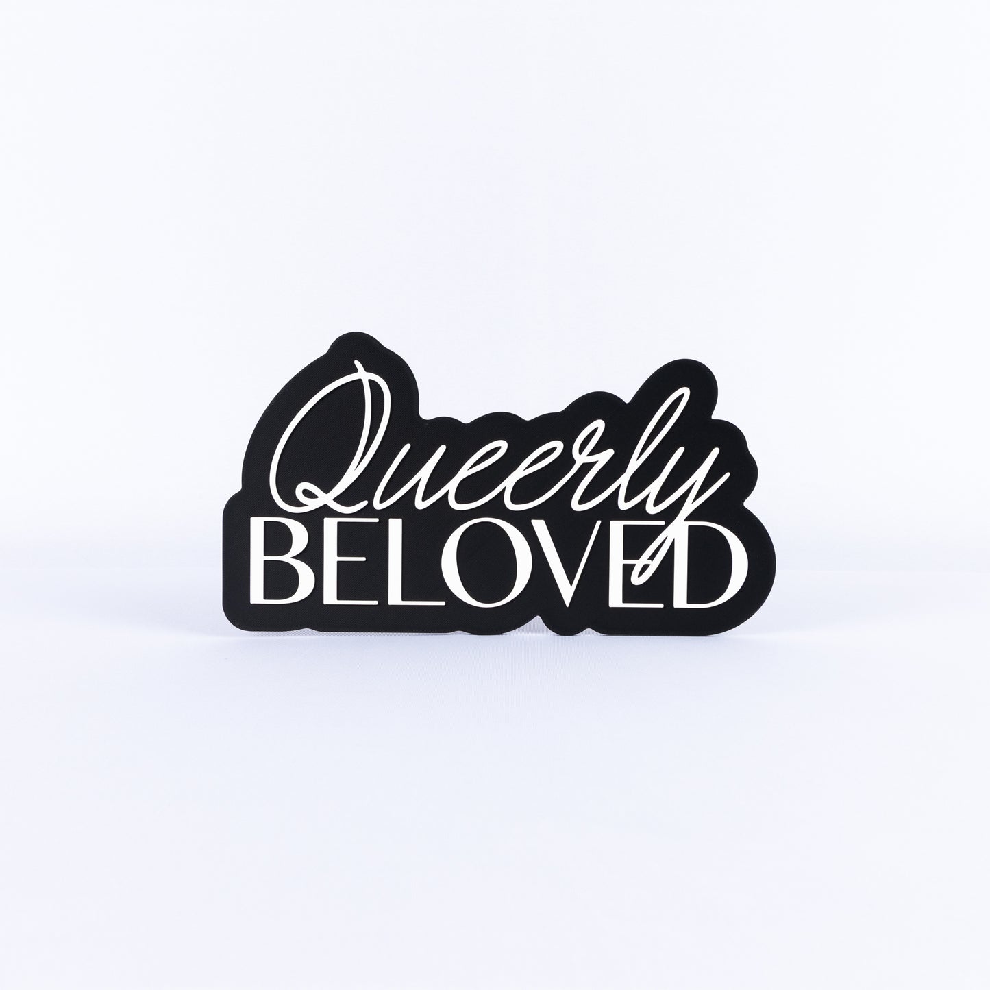 Black and white sign with 'Queerly Beloved' text on a white background