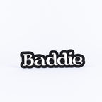 Black and white sign with 'Baddie' text on a white background