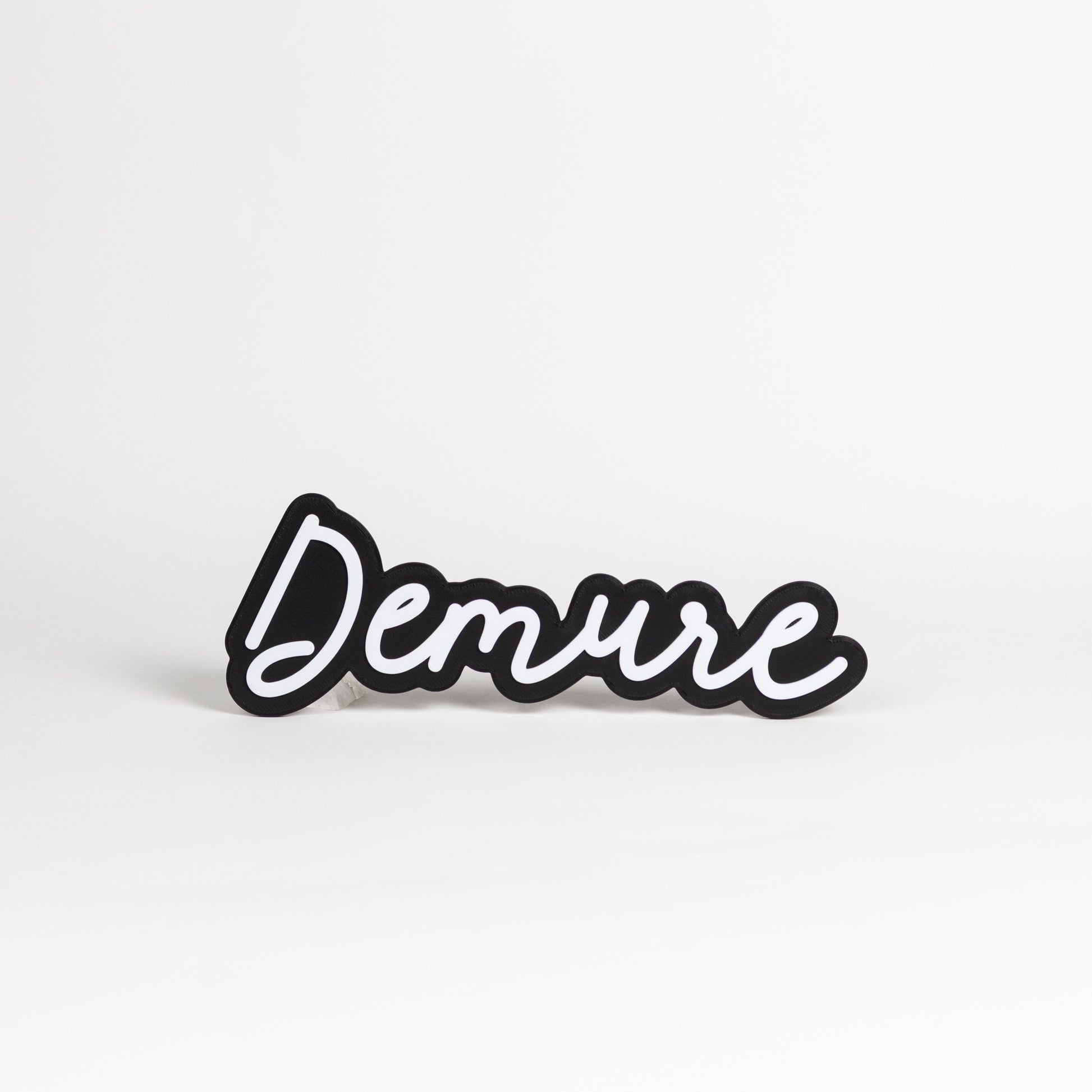 Black and white 'Demure' sign on a white background.