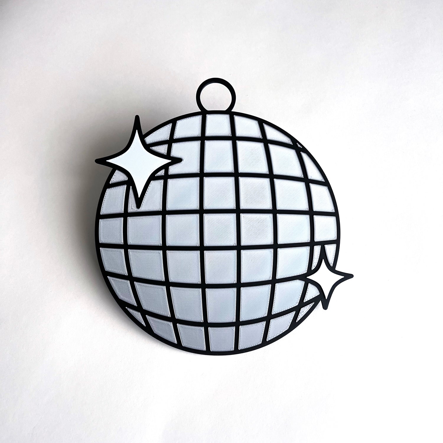 3D printed disco ball prop sign with reflective silver tiles and white sparkle accents.