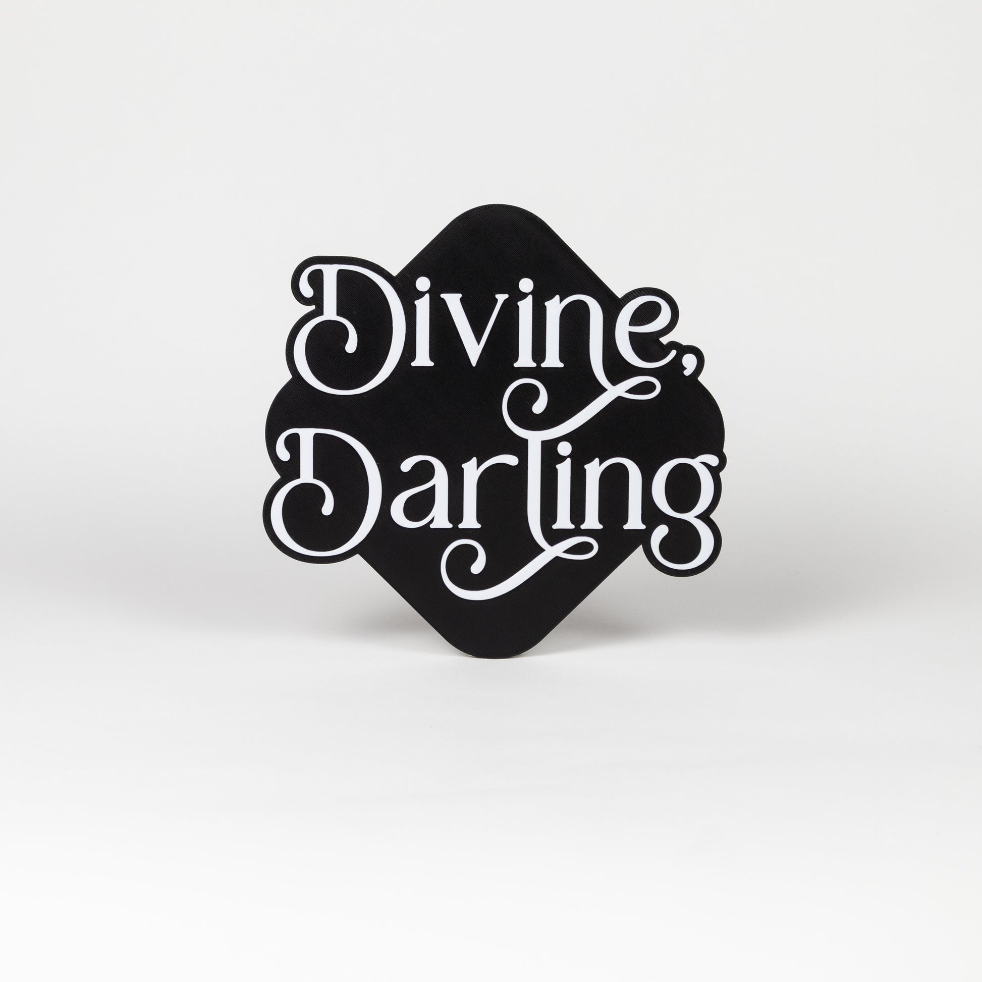 Black and white photo booth prop with 'Divine, Darling' text on a white background.