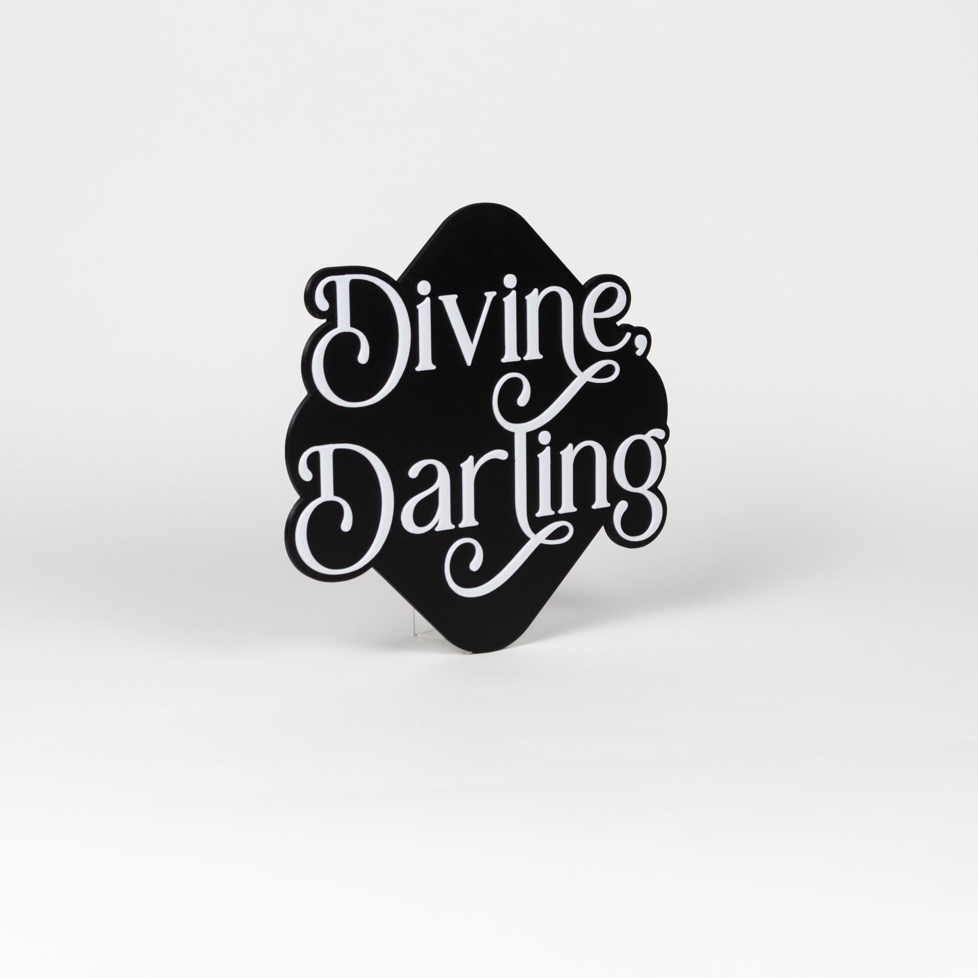 Orthogonal view of black and white sign with 'Divine Darling' text on a white background