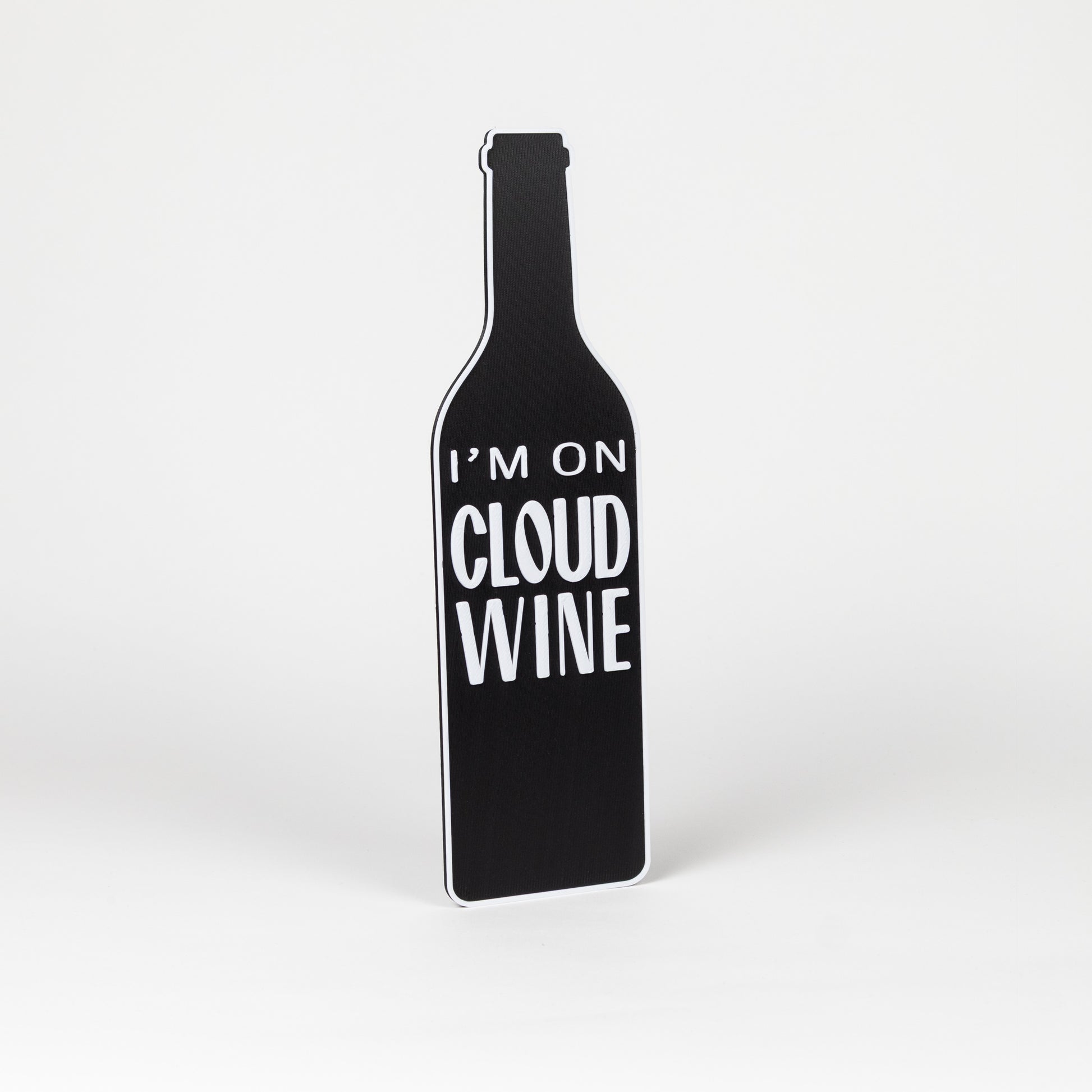 Photo booth prop. Black wine bottle-shaped object with 'I'm on Cloud Wine' text on a white background