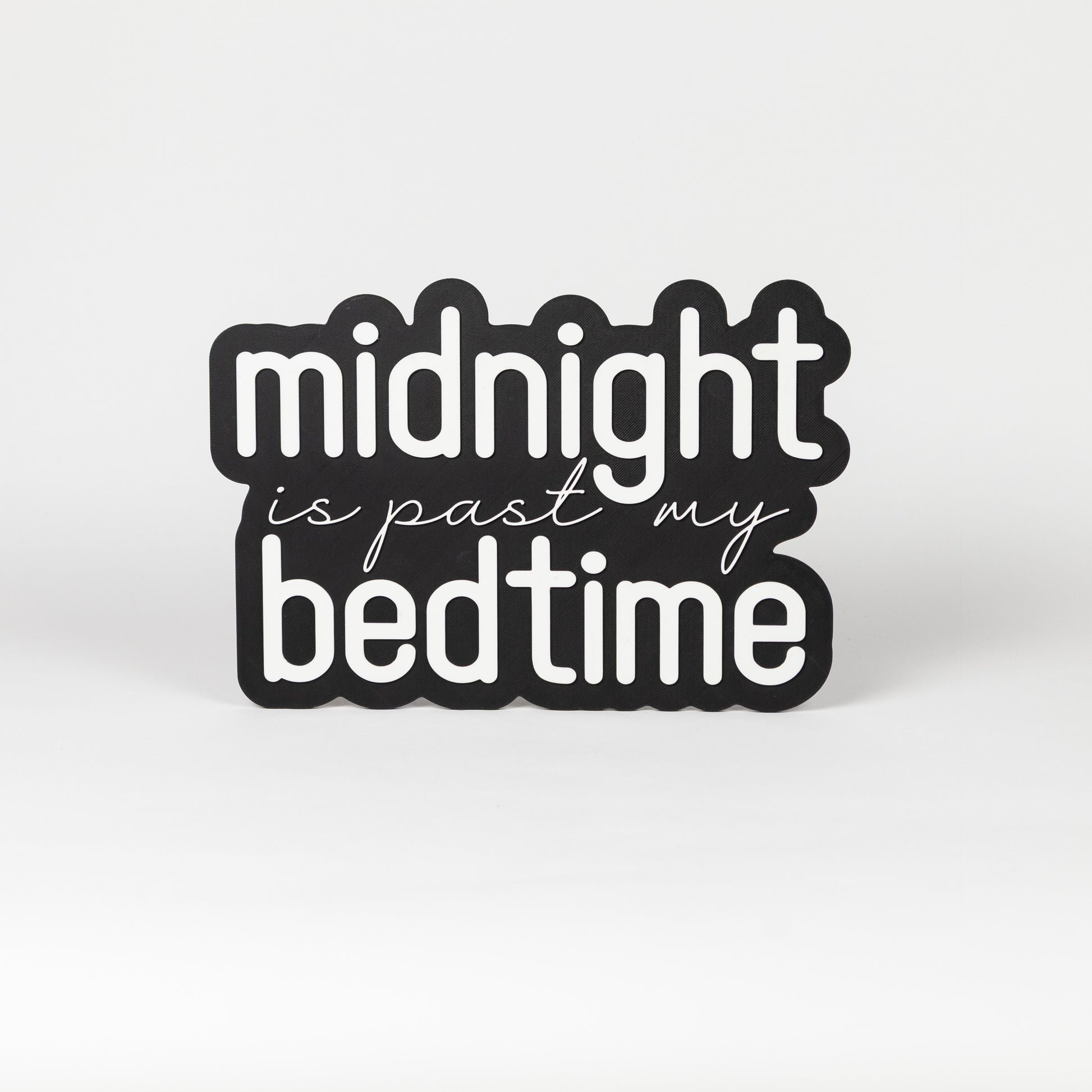 Photo booth prop sign. Black base with 'midnight is past my bedtime' white text on a white background