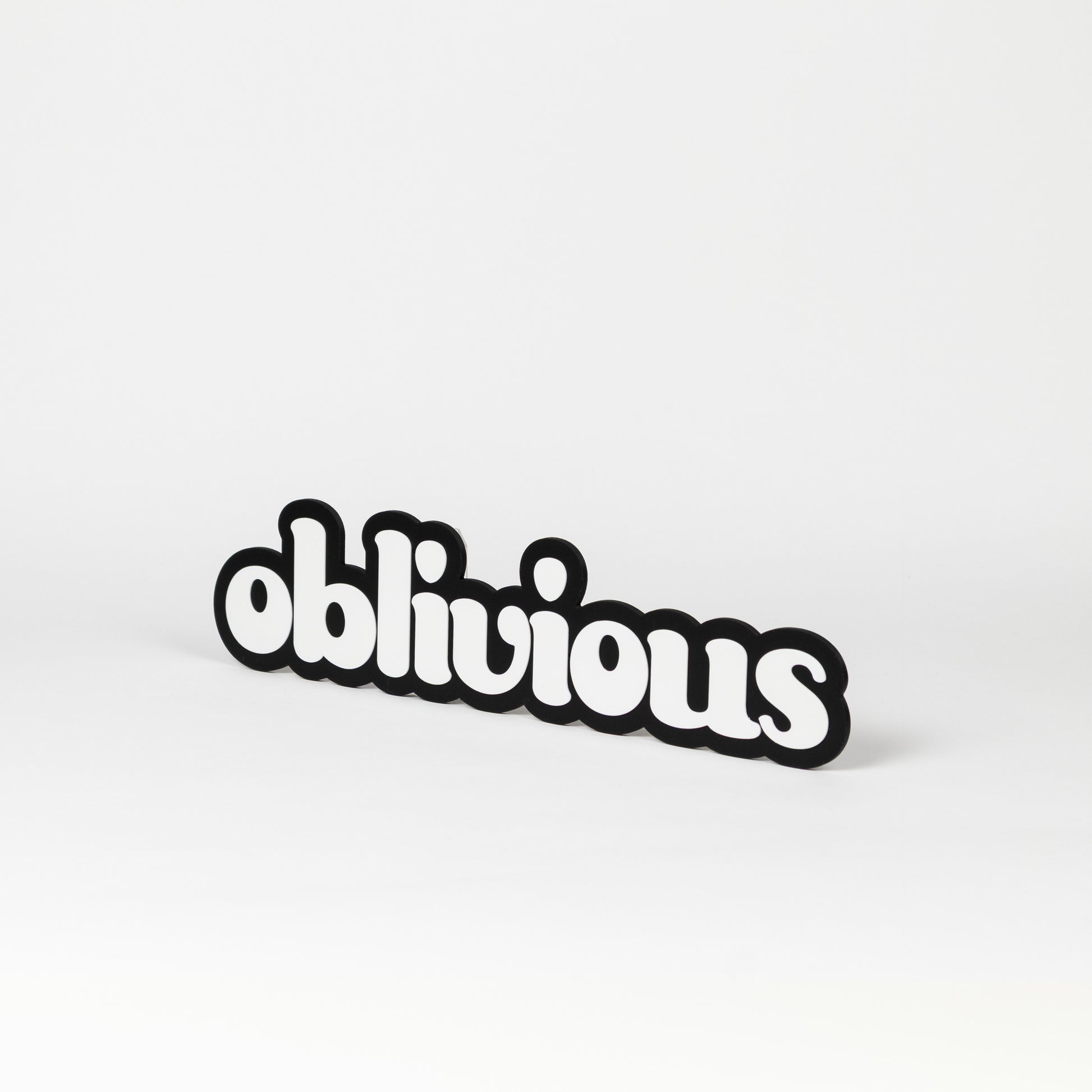 Black and white photo booth prop of the word 'oblivious'. 