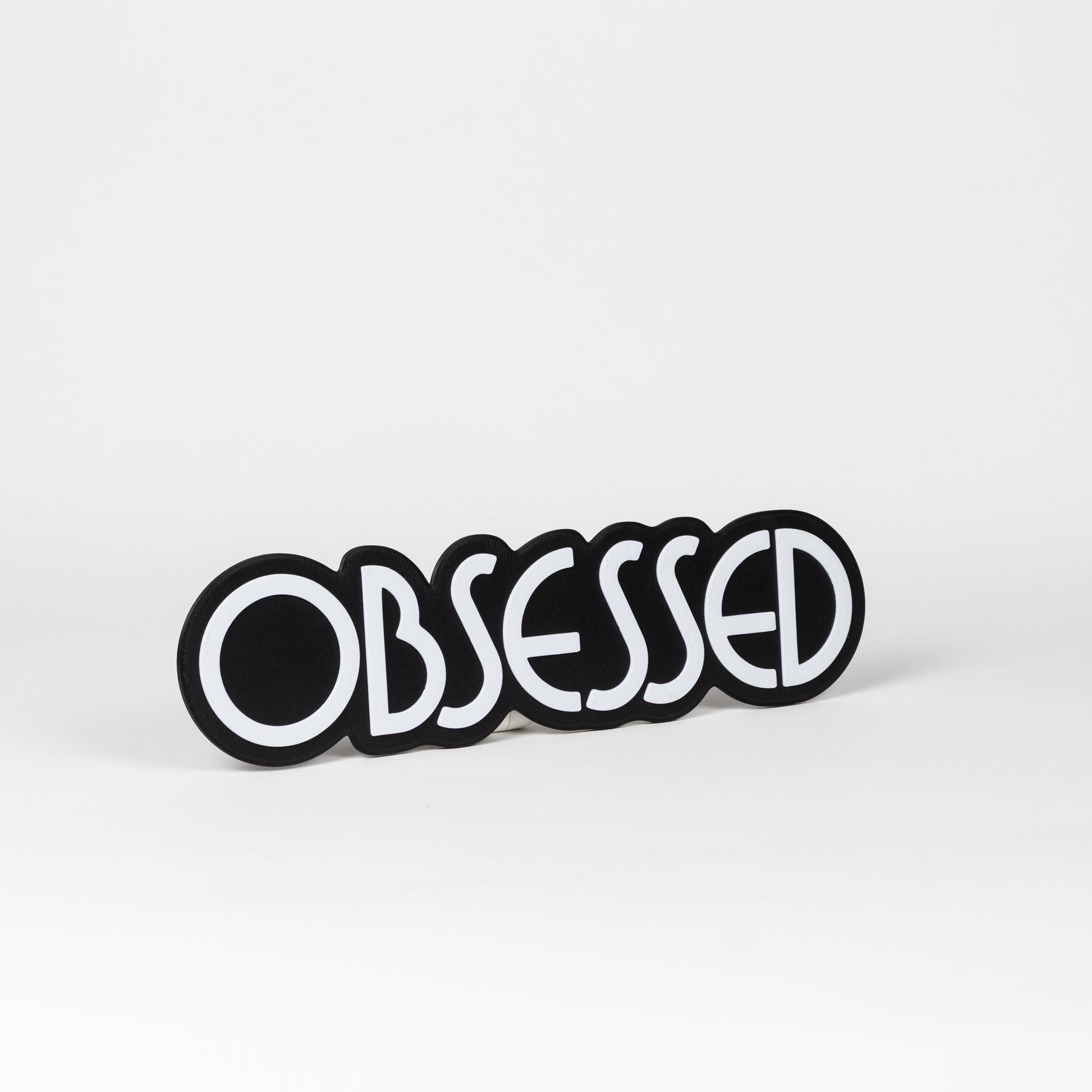 Black and white "Obsessed" sign. Photo booth prop.
