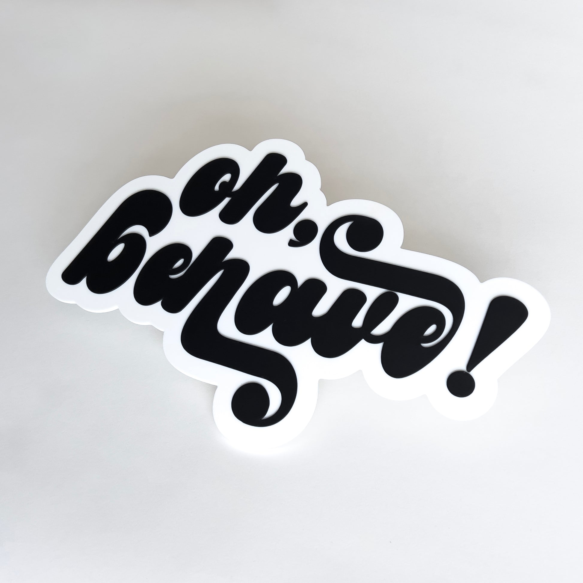 White and black photo booth prop sign that says "oh, behave!".