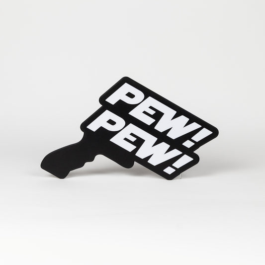 Black and white sign that says "Pew Pew!". Sign is in the shape of a Star Wars blaster. Photo booth prop.