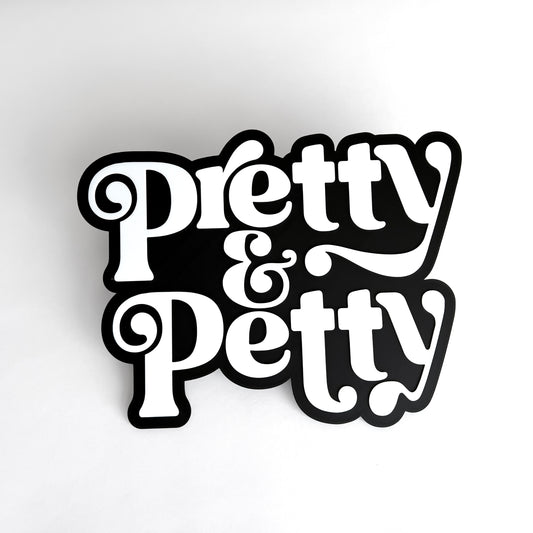 Black and white sign that says "Pretty and Petty" for photo booth events.