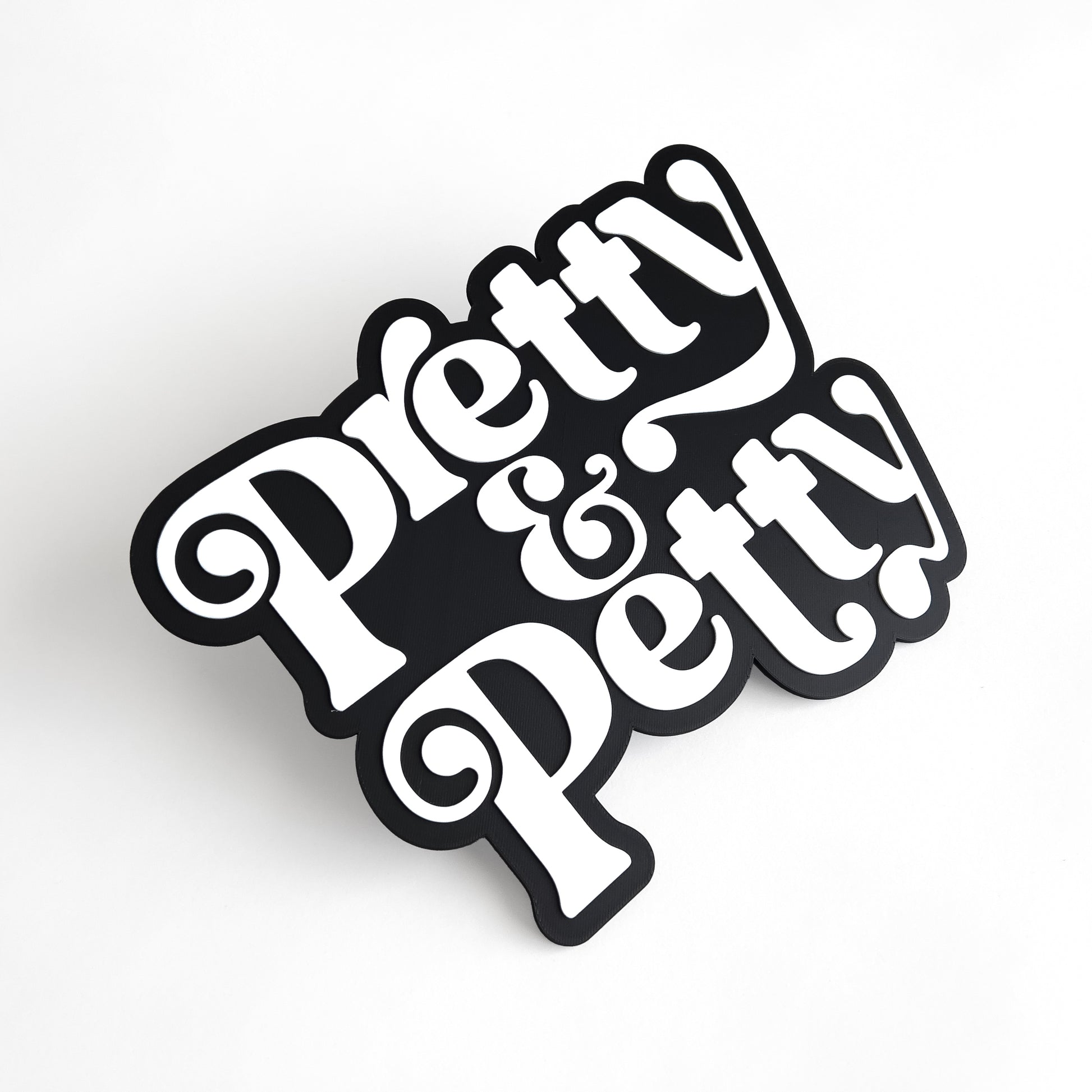 Black and white sign that says "Pretty and Petty" for photo booth events.