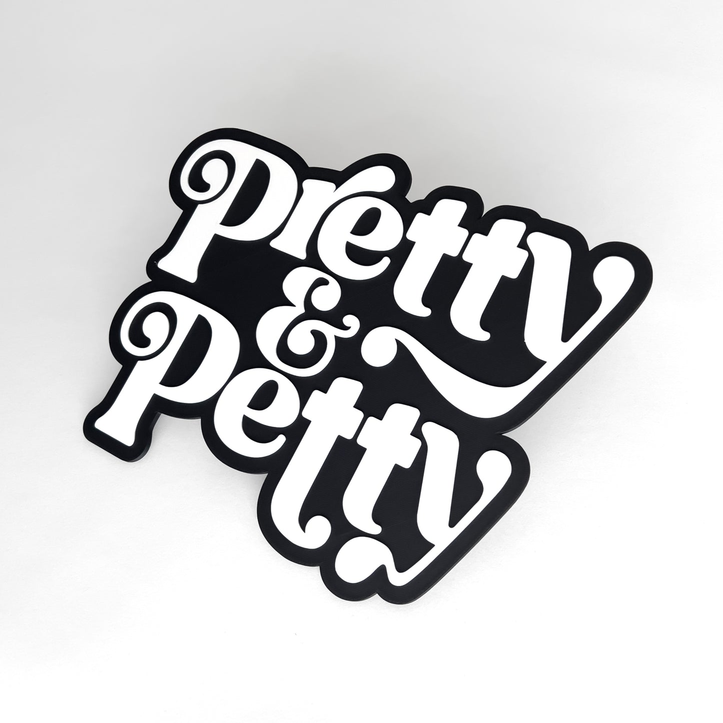 Black and white sign that says "Pretty and Petty" for photo booth events.