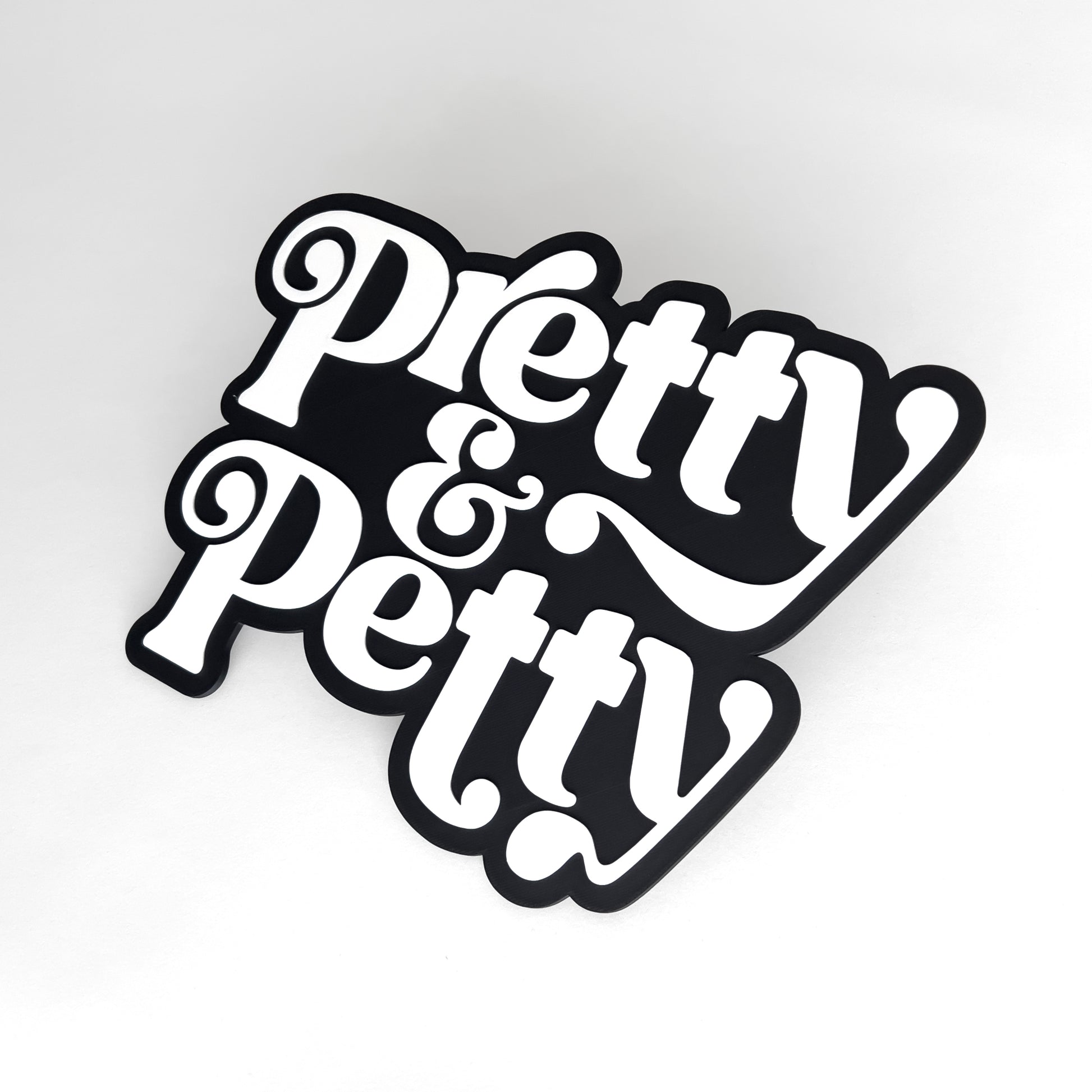 Black and white sign that says "Pretty and Petty" for photo booth events.