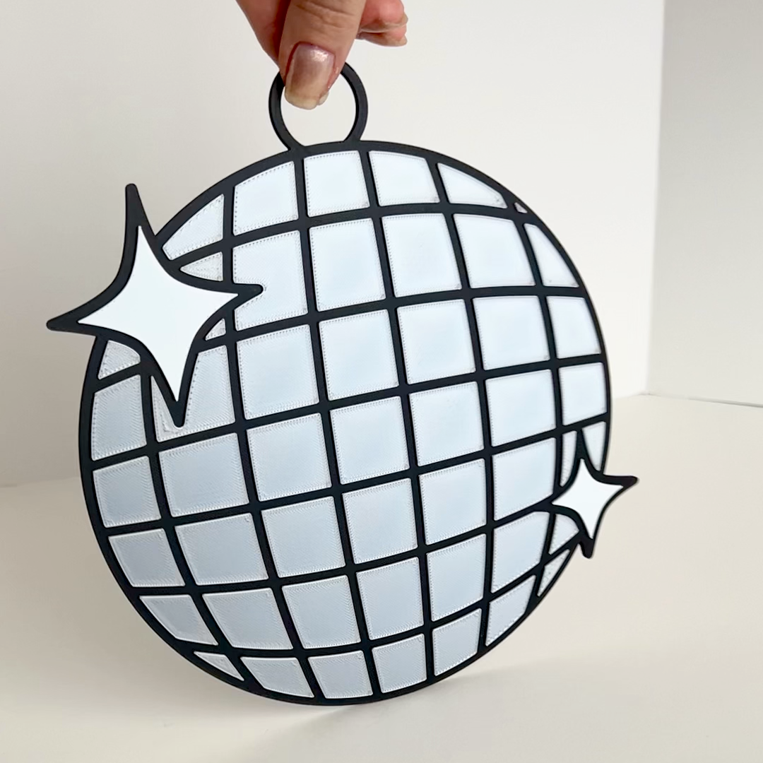 Video of a disco ball photo booth prop showing reflective silver tiles