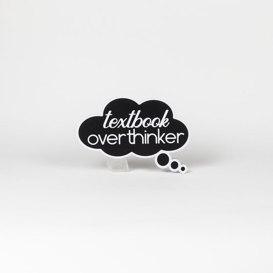 Black cloud-shaped sign with 'textbook overthinker' text in white. Photo booth prop shot on a white background.