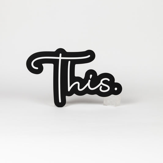 Black and white sign of the word "This." Photo booth prop of popular saying.